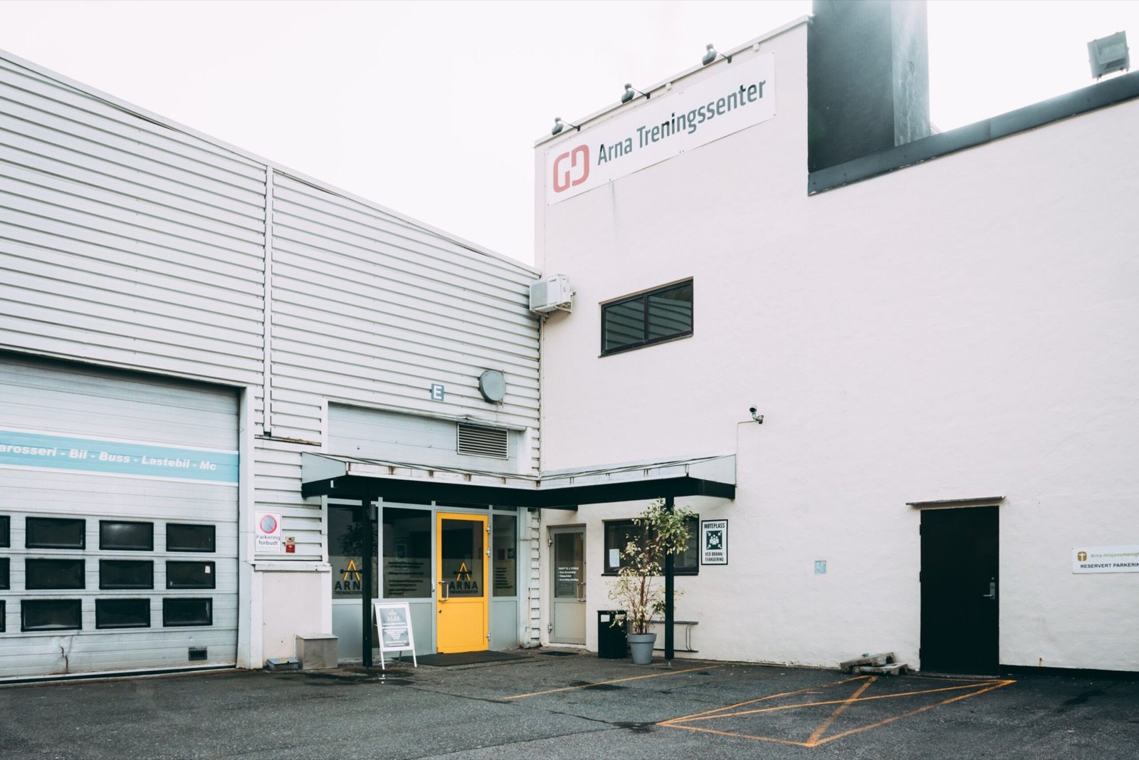 Arna Treningssenter sett utenfra, med parkeringsplass foran inngangen