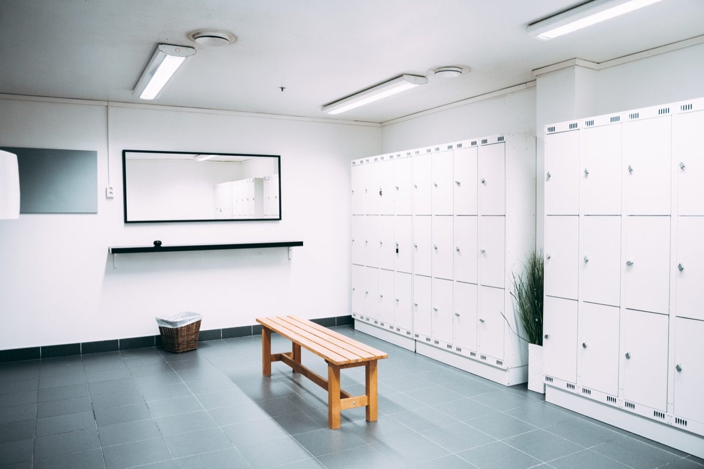 Lys garderobe med hvite skap og en trebenk